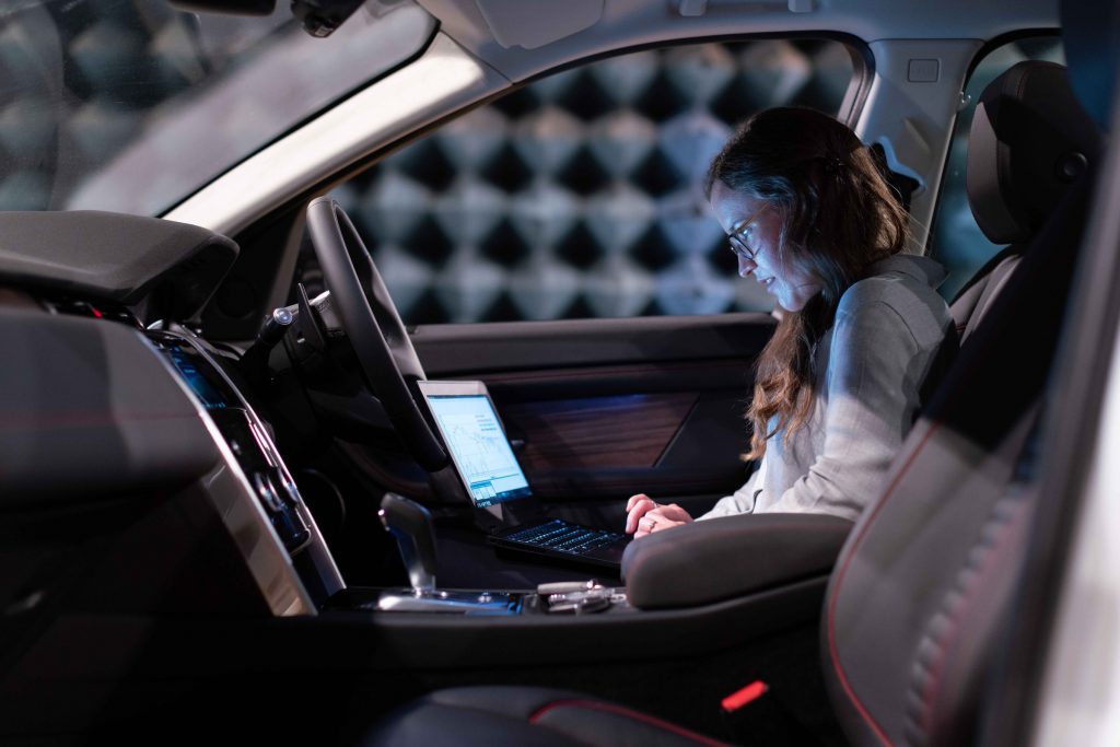 The tech behind Tesla - Female engineer working inside car